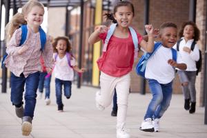 Young children running with backpacks