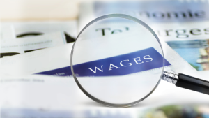 wages magnified by a magnifying glass